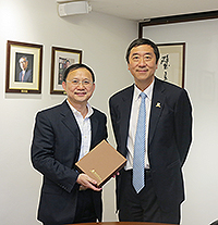 Prof. Joseph Sung (right), Vice-Chancellor of CUHK, presents a souvenir to Prof. Luo Qingming, Vice-President of Huazhong University of Science and Technology